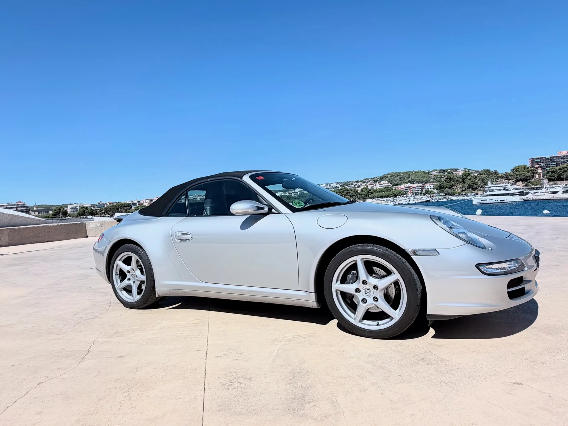 Complete silver Porsche 911 Carrera 4 Cabriolet in a front-side profile with the roof raised