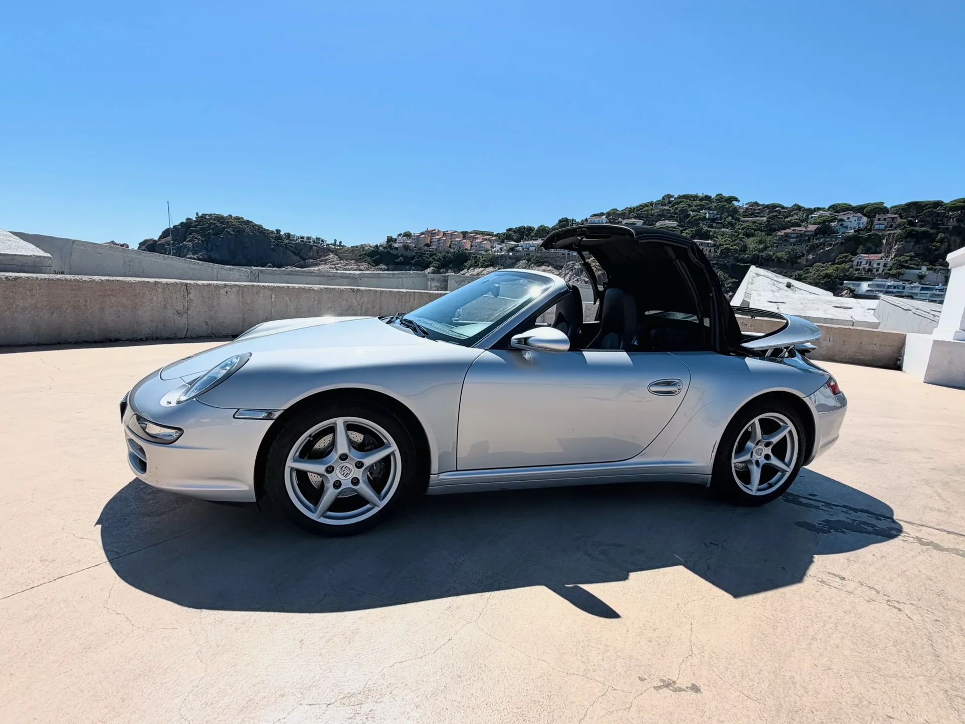 Complete silver Porsche 911 Carrera 4 Cabriolet in a side profile with the roof raised